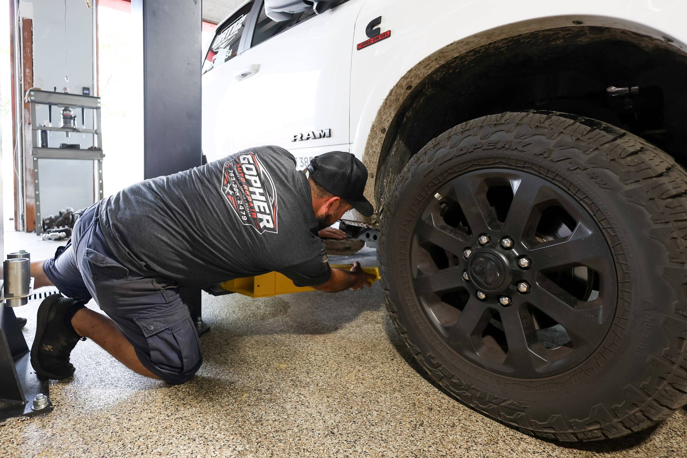 The owner kneeling at the front wheel of a raised pickup